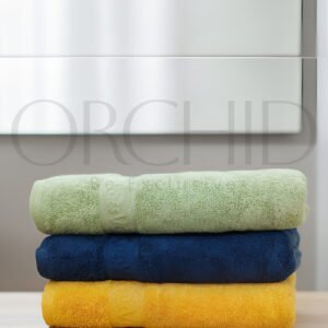 Zero Twist Cotton Bath Towel in premium quality, 27x54 size, soft and absorbent bath towel in white, light blue, and tea pink colors placed in a modern bath vanity.